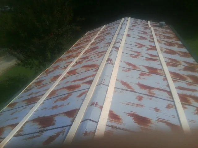 Rusted metal roof panels with new wood purlins before replacement — Storm Damage Roof Repair in Marmora by Roofing Brothers