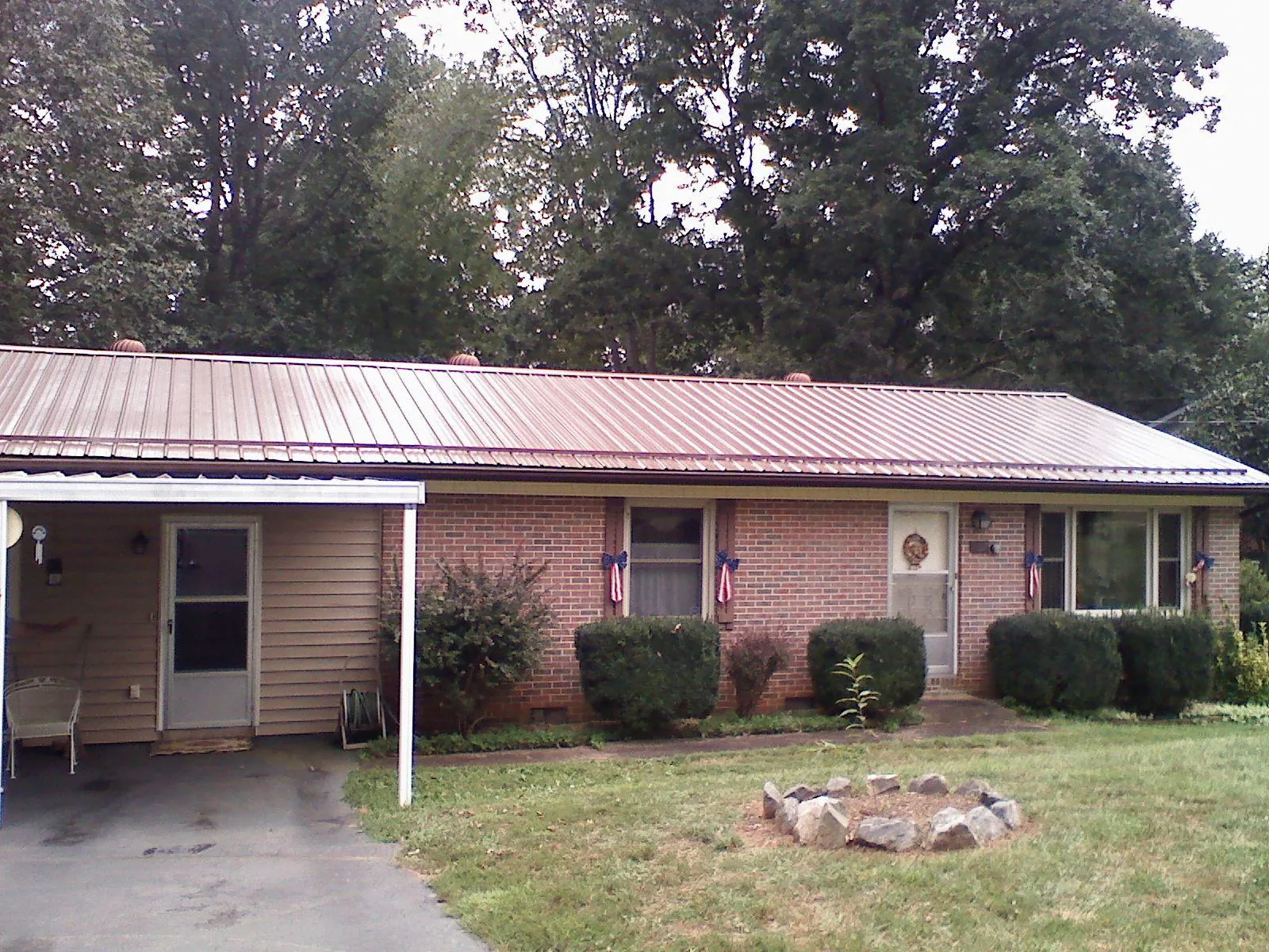 Bronze metal roof and carport on a brick ranch home — Roof Repair work by our crew in Marmora